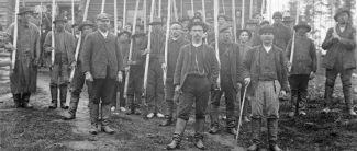 Torpan pihamaalla on uittajia seisomassa keksit eli uittohaat käsissä.