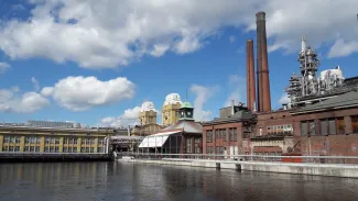 Tehdasmaisema, keskellä kanava, kaksi savupiippua ja vanhoja tehdasrakennuksia