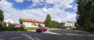 Punainen auto ajaa Kangaslammin asiointipisteen ohi.