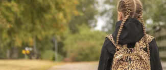 Koululainen reppu selässä koulumatkalla.