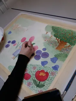 Ihminen maalaa kuvataideteosta.