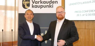 Toimitusjohtaja Peng Zhang ja kaupunginjohtaja Joonas Hänninen kättelevät datakeskuksen mediatilaisuudessa.