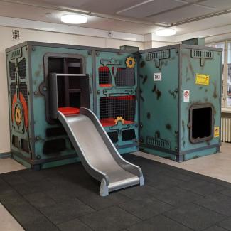 Lasten tehtaan liukumäki joka näyttää paperikoneelta