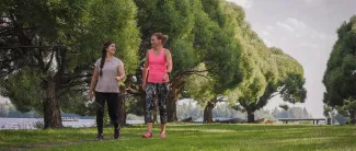 Kaksi naista kävelyllä Hertunrannassa.