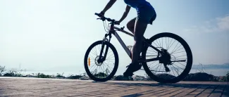 Pyöräilijä, järvi taustalla.