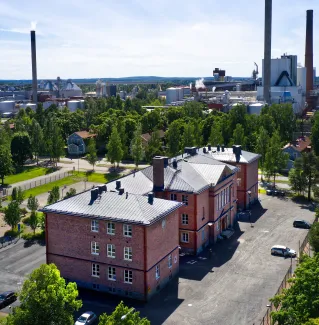 Ilmakuva Vanhasta Varkaudesta, jossa näkyy punatiilinen museokeskus Konsti ja taustalla tehtaan piippuja