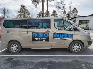 harmaa pakettiauto parkkipaikalla, jonka kyljessä teksti: Walkers Warkaus 